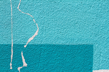 Colorful (light and dark blue) painted wall with paper scraps as background or texture