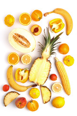 Assorted vegetables and fruits in yellow on a white background. Top view