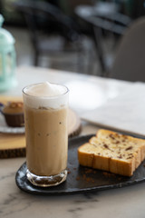 A baked bread served with a glass of iced coffee
