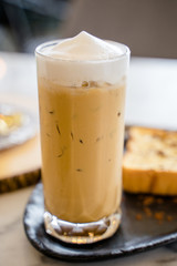 A baked bread served with a glass of iced coffee