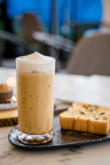 A baked bread served with a glass of iced coffee