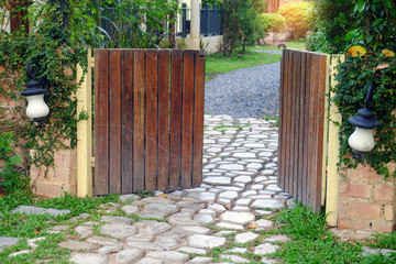 Opening wood gate to the outside stone walkway