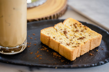 A baked bread served with a glass of iced coffee