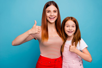 Excited foxy small lady and her mom approving good quality of product wear casual clothes isolated blue background