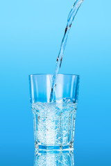 Close up pouring purified fresh drink water from the bottle on table
