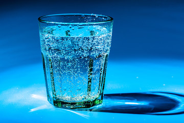 glass of water on a table  on a dark background