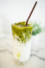 Iced Green milk tea macchiato in the glass with straw.