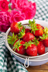 Heap of fresh strawberries in ceramic bowl on rustic background