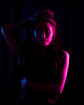 young high fashion model girl in colorful bright sparkles and neon lights posing in a full-length studio, portrait of a beautiful sexy woman. Art design colorful shiny fashionable glowing bright makeu