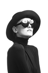 Stylish black and white portrait of elegant slim girl in glasses and a hat.