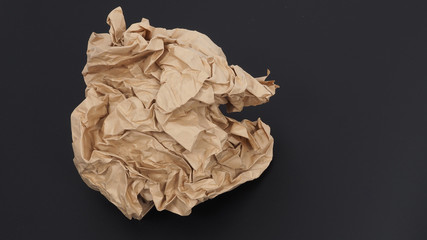 Crumpled brown paper.It is mauled on black background.