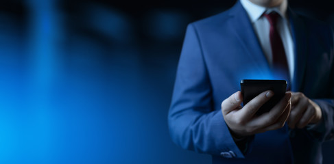 Businessman holding smartphone. Man using phone in office