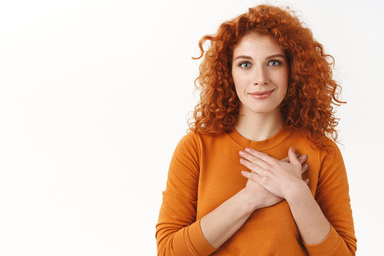 Your Support Mean A Lot. Touched Tender Gorgeous Redhead Woman With Blue Eyes, Curly Haircut, Press Hands To Heart Grateful, Smiling Pleased, Thankful For Nice Gift, Appreciate Help, White Background