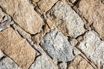 Detail of an old stone wall arranged in an irregular manner. Architecture constructions. Vintage background. Oblique lines.