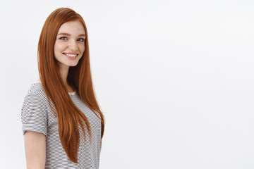 Self-assured motivated redhead talented female student blue eyes wearing striped t-shirt standing profile turning camera smiling look professional confident, white background
