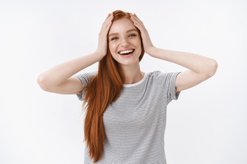 Carefree delighted amused happy charming ginger girl blue eyes grab head hands surprised reacting awesome good news perfect b-day surprise thankfully grinning laughing cheerfully, white background
