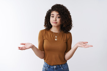 Not big deal. Unbothered careless stylish young modern female curly dark hair shrugging hands...