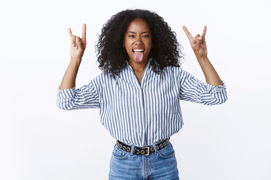 Wild Good-looking Attractive Curly-haired African American Woman Party Rock Having Fun Showing Heavy Metal Gestures Stick Tongue Dancing Awesome Music, Partying Enjoying Cool Concert White Background