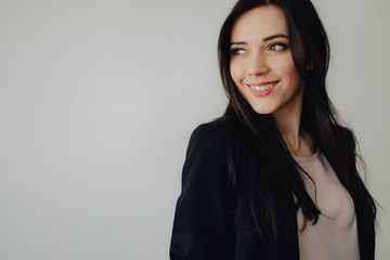 Obraz premium Young attractive emotional girl in business-style clothes on a plain white background in an office or audience