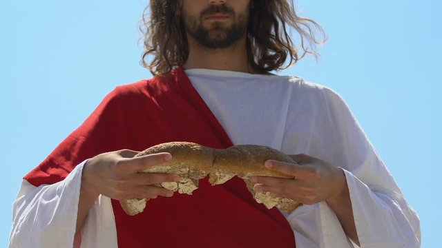 Righteous man breaking bread equally, religious concept to share with hungry