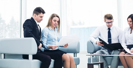 employees of the company with documents sitting in the reception room before the conference