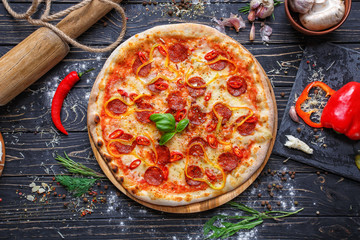 Burning pizza with sausage, bulgarian pepper and chili pepper