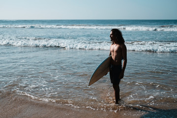 Man Surfer Sitting at Surfboard on Sand Beach
