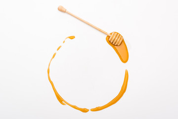 top view of round honey frame with copy space and wooden honey dipper isolated on white