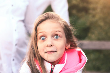 portrait of a surprised little girl on a walk in the Park on a S