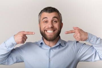 Caucasian man smiling and showing perfect teeth