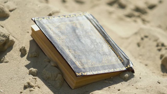 Old book Quran abandoned in sand, forgotten ancient knowledge, rejected religion