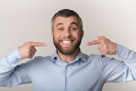 Caucasian man smiling and showing perfect teeth