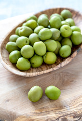green olives in wooden bowl
