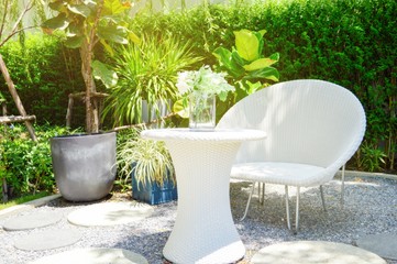 White wicker chair and white wicker table in the garden with light at morning.Relax concepts.