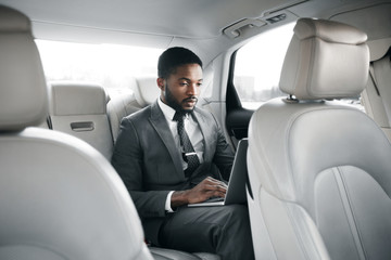 Fototapeta na wymiar Handsome businessman working on laptop in car