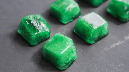 Green ice cubes lined up in rows