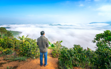 Silhouette of man standing on a high hill scenic rural hometown in the morning valley fog shrouded mountains looming large undulating scenic spot