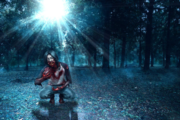 Scary zombies with blood and wound on his body eating the raw meat in the haunted forest with moonlight