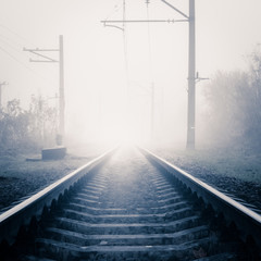 Railway track on misty foggy morning day in autumn
