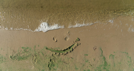 smiley painted on the sand 