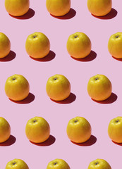 Seamless pattern with yellow apples on a pink background