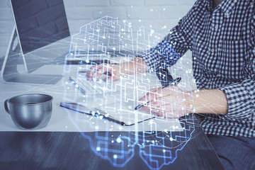 Man typing on keyboard background with brain hologram. Concept of big Data. Double exposure.