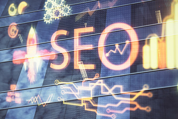 SEO hologram on city view with skyscrapers background double exposure. Search optimization concept.