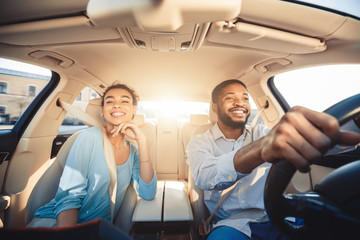 Enjoying travel. Excited african couple driving car