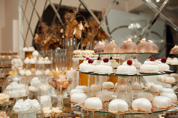 Candy bar with tasty desserts  at wedding reception. Sweet food, dessert, buffet, catering table, restaurant. Beautiful modern decoration sweets on table.