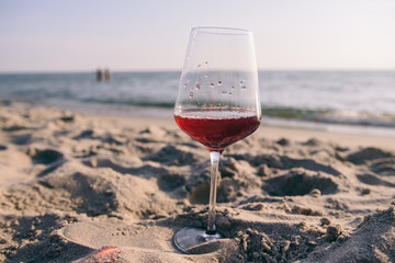 glass of red wine at sunset on the sea coast