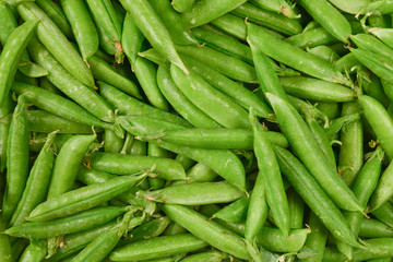 Fresh pea pods as background. Top view.