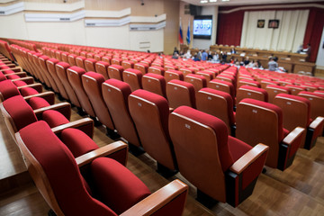 Close-up shot of red chair seats in empty conference room