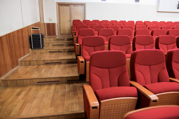 Close-up shot of red chair seats in empty conference room