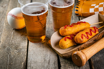 Selection of stadium game foods - nachos, pop corn, pretzels, corn dogs, rustic wood background